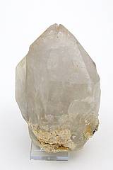 Abb. zeigt einen 13 cm großen Bergkristall am Fuß kann mann noch die Spuren vom Pegmadit erkennen.
